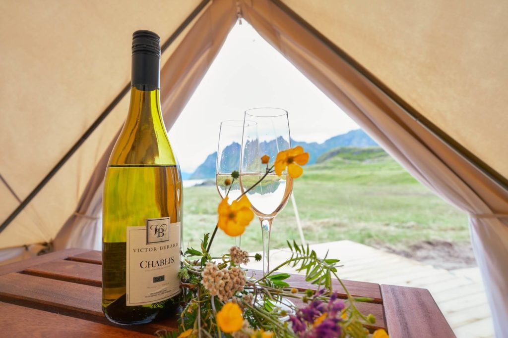 Romantic meal with white wine in a glamping tent